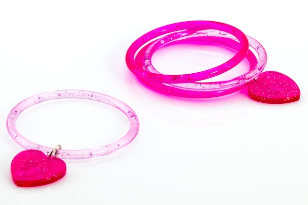 Uma Pulseira Rosa Adornada Com Formas De Coração, Colocada Sobre Um Fundo Branco.