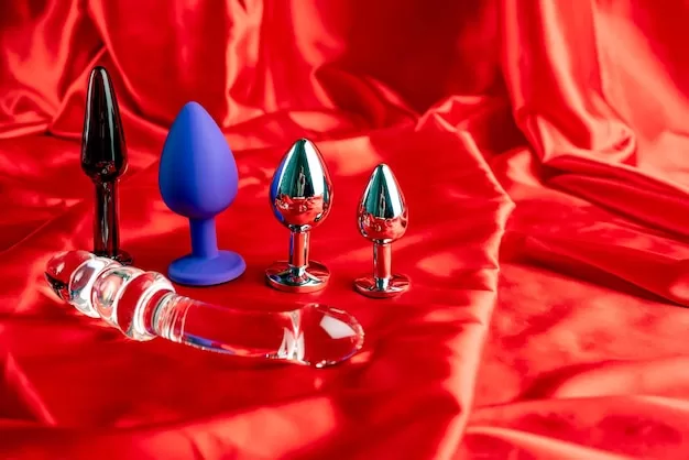 Uma Coleção De Diversos Tipos De Brinquedos Sexuais Para Casais Exibidos Sobre Um Fundo De Cetim Vermelho, Incluindo Vibradores E Outros Acessórios íNtimos.