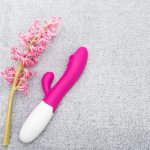 Um Arranjo Vibrante De Flores Ao Lado De Um Vibrador Rosa, Criando Uma Atmosfera Relaxante E Convidativa.