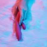 Uma Mulher Deitada Em Uma Cama, Segurando Um Dildo Na Mão, Envolvida Em Autoexploração.