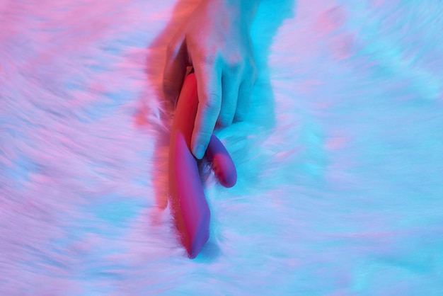 Uma Mulher Deitada Em Uma Cama, Segurando Um Dildo Na Mão, Envolvida Em Autoexploração.