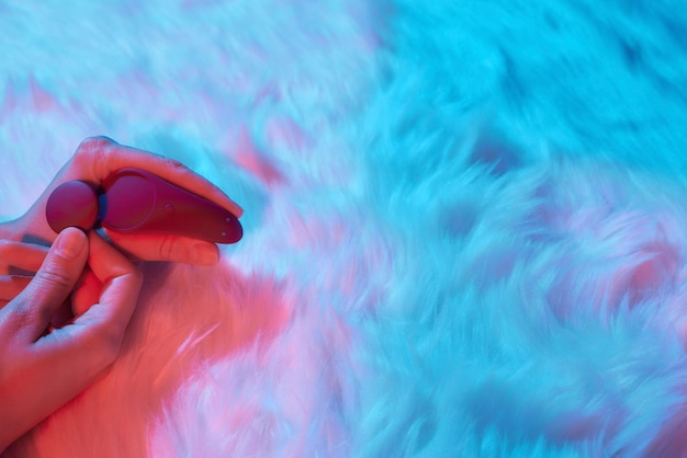 Uma Mulher Deitada Em Uma Cama, Segurando Um Vibrador Na Mão, Concentrando-se Em Seu Próprio Prazer.