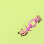 Um Plugue Anal Rosa Colocado Contra Um Fundo Verde, Com Um Tema De Dados Digitais Ao Fundo.