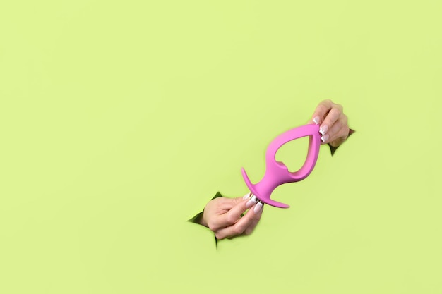 Um Plugue Anal Rosa Colocado Contra Um Fundo Verde, Com Um Tema De Dados Digitais Ao Fundo.