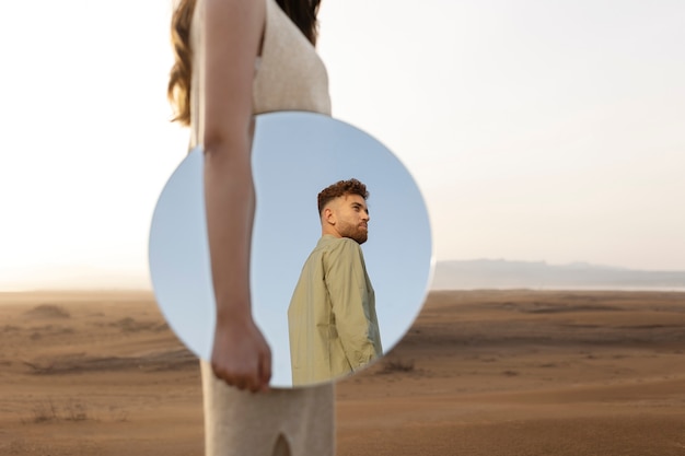 Uma Vista Lateral De Uma Mulher Segurando Um Espelho, Refletindo Sobre Seu Crescimento Pessoal E Autoaceitação.