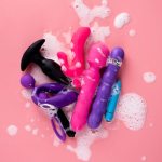 Close-up De Uma Pessoa Limpando Brinquedos Sexuais Com Um Pano, Enfatizando Práticas De Segurança E Higiene.