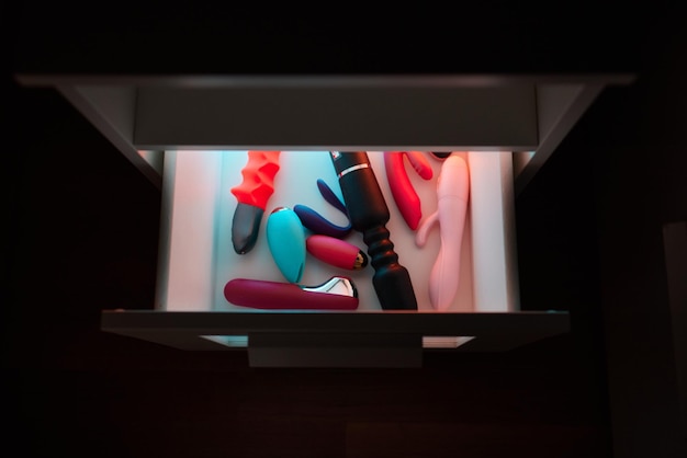 Interior De Uma Loja Exibindo Uma Variedade De Produtos Eróticos Dispostos Em Gavetas De Baú Abertas.