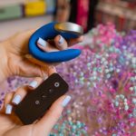 Uma Mão Segurando Um Vibrador Massageador Projetado Para Estimulação Sexual, Ambientado Em Um Sex Shop Discreto E Respeitoso.