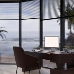 Um Escritório Privado Moderno Com Uma Mesa De Madeira E Um Mockup De Computador, Situado Ao Lado De Uma Grande Janela De Vidro Que Permite A Entrada De Luz Natural.