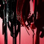 Um Interior De Sex Shop Contemporâneo Com Uma Parede Vermelha Adornada Com Vários Brinquedos Sexuais Pendurados, Criando Uma Atmosfera Convidativa.